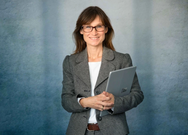 Frau mit Laptop in der Hand und Businessoutfit
